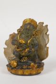 A Sino Tibetan moulded smoked glass figure of a wrathful deity, with gilt highlights, 4" high
