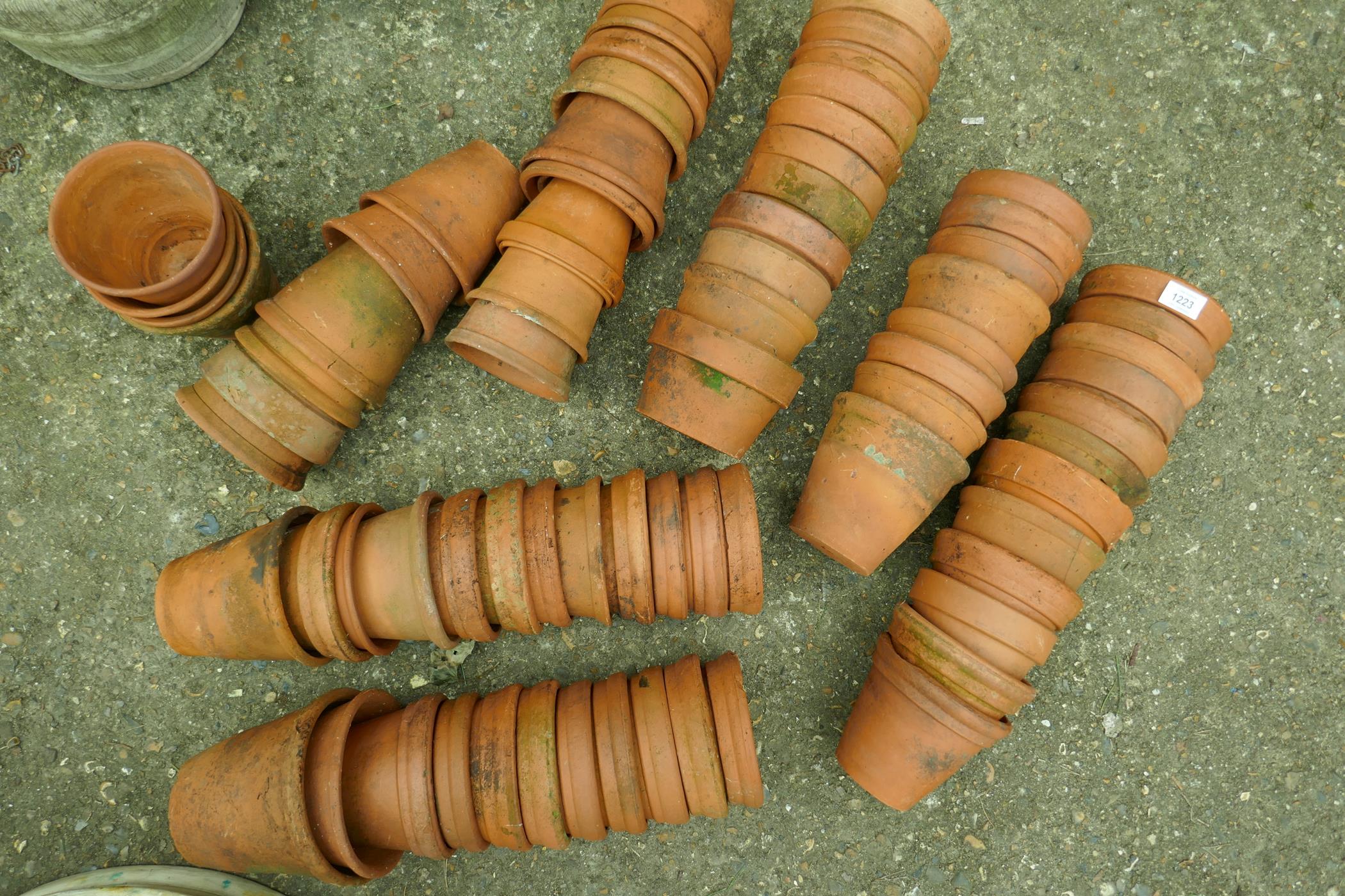 A large collection of terracotta plant pots, approx 70, 6" diameter