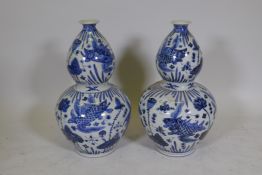 A pair of Chinese blue and white porcelain double gourd vases decorated with carp in a lotus pond,