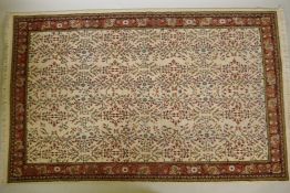 An old Turkish Hereke hand woven cream ground woven wool rug with an allover floral design, 55" x