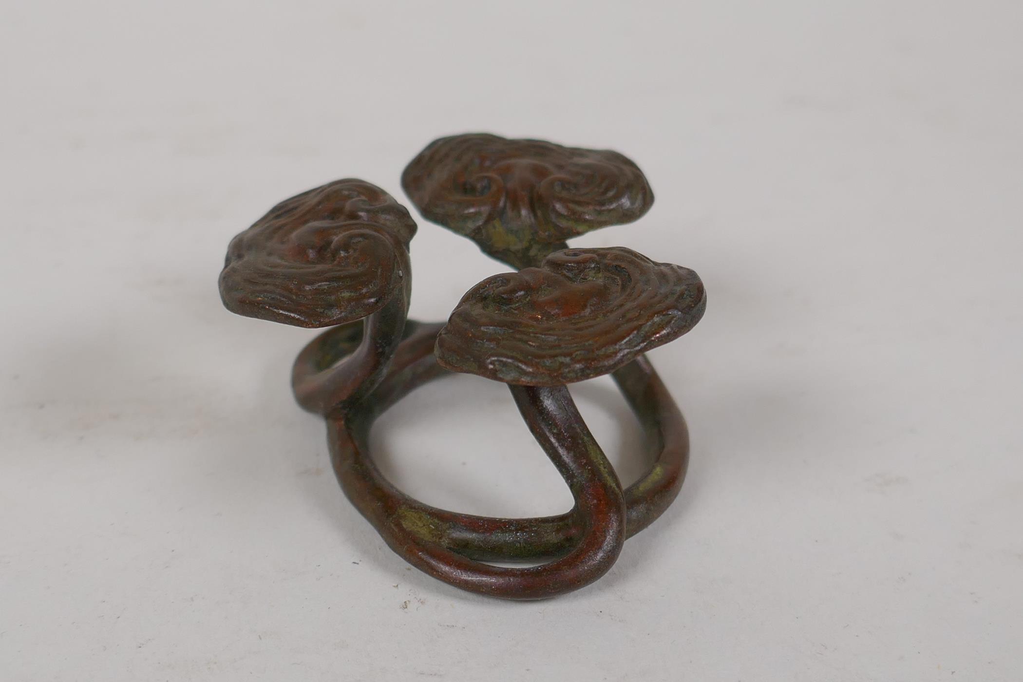A Chinese bronze brush rest in the form of entwined ruyi, 2" diameter - Image 2 of 2