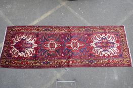 A Persian red ground Heritz runner with a starburst medallion design, 46" x 131"