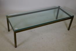 A bespoke solid brass coffee table with a plate glass top, 22" x 56" x 17"
