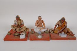 Three Indian painted and plastered papier mache  seated figures, AF, largest 4" high