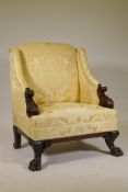 An imposing wing back armchair in the manner of William Kent, with carved and scrolled arms,