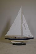 A painted wood model of a yacht, mounted on a stand, 26" long x 34" high
