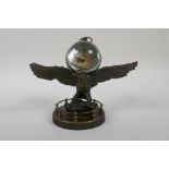 A brass bound ball desk clock mounted on a metal eagle, 7" wide