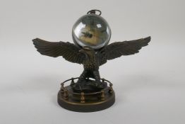 A brass bound ball desk clock mounted on a metal eagle, 7" wide