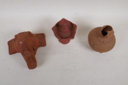 An Indian terracotta oil burner, a terracotta elephant wall mask and a terracotta vase, AF,