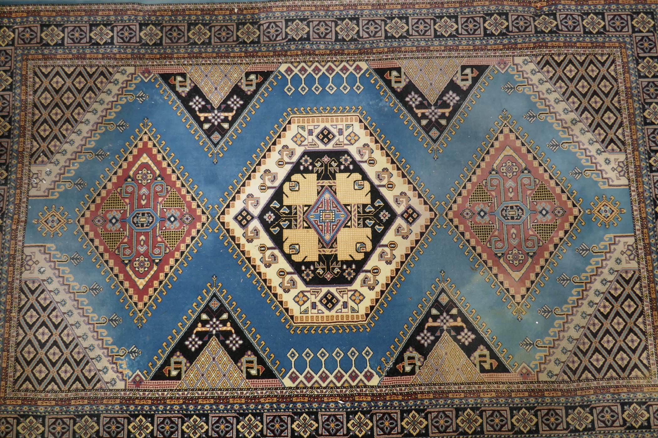 An oriental blue ground wool rug, decorated with a geometric medallion design, 63" x 99" - Image 2 of 4