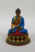A Sino Tibetan painted moulded glass figure of Buddha seated on a lotus throne, engraved 4 character