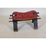 A traditional camel saddle with buttoned leather cushion, 15" high, 28" long