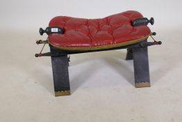 A traditional camel saddle with buttoned leather cushion, 15" high, 28" long