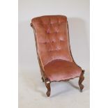 A Victorian balloon back nursing chair raised on turned supports with brass castors
