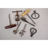 A collection of five antique corkscrews, two champagne taps and a can opener