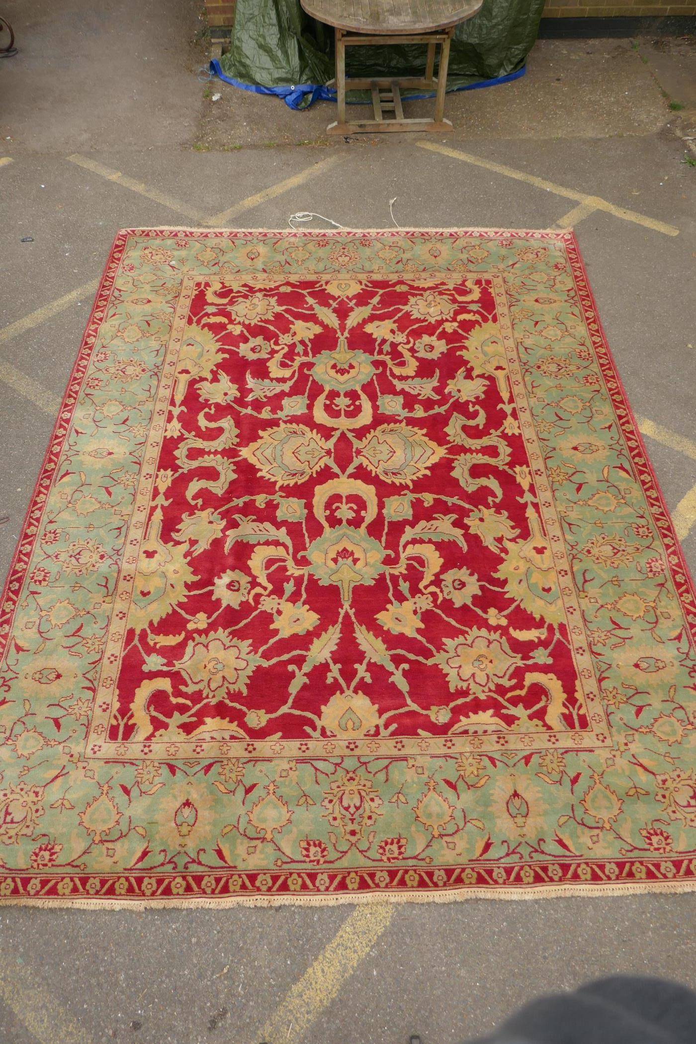 An antique red ground Agra carpet with floral design and olive green borders, AF wear, 108" x 140" - Image 2 of 8
