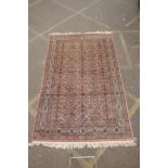 A Persian terracotta ground full pile wool carpet, decorated with an all over geometric design,