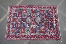 An old full pile Persian Bakhtiari village rug with a panelled design, dated/signed?, 66" x 95"
