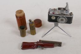 Three humourous cigarette lighters, a camera on a tripod, double barrel shotgun and treen medicine