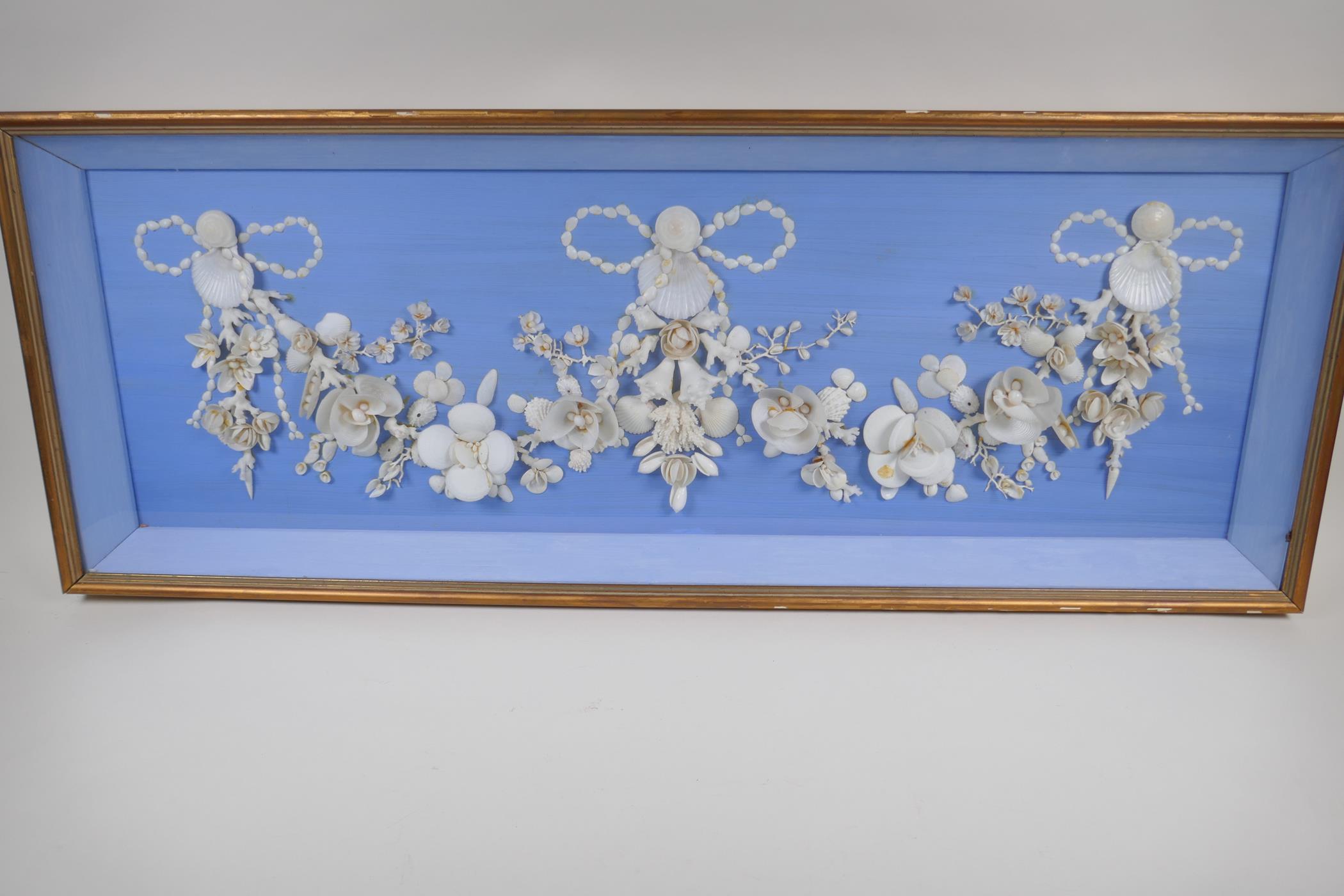 A shell picture of a floral garland and fairies, 38" x 13½"