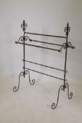 A Gothic style wrought iron towel rail with brass terminals, 40" high, 31" wide