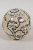 A bone globe, opening to reveal a compass, 3" diameter