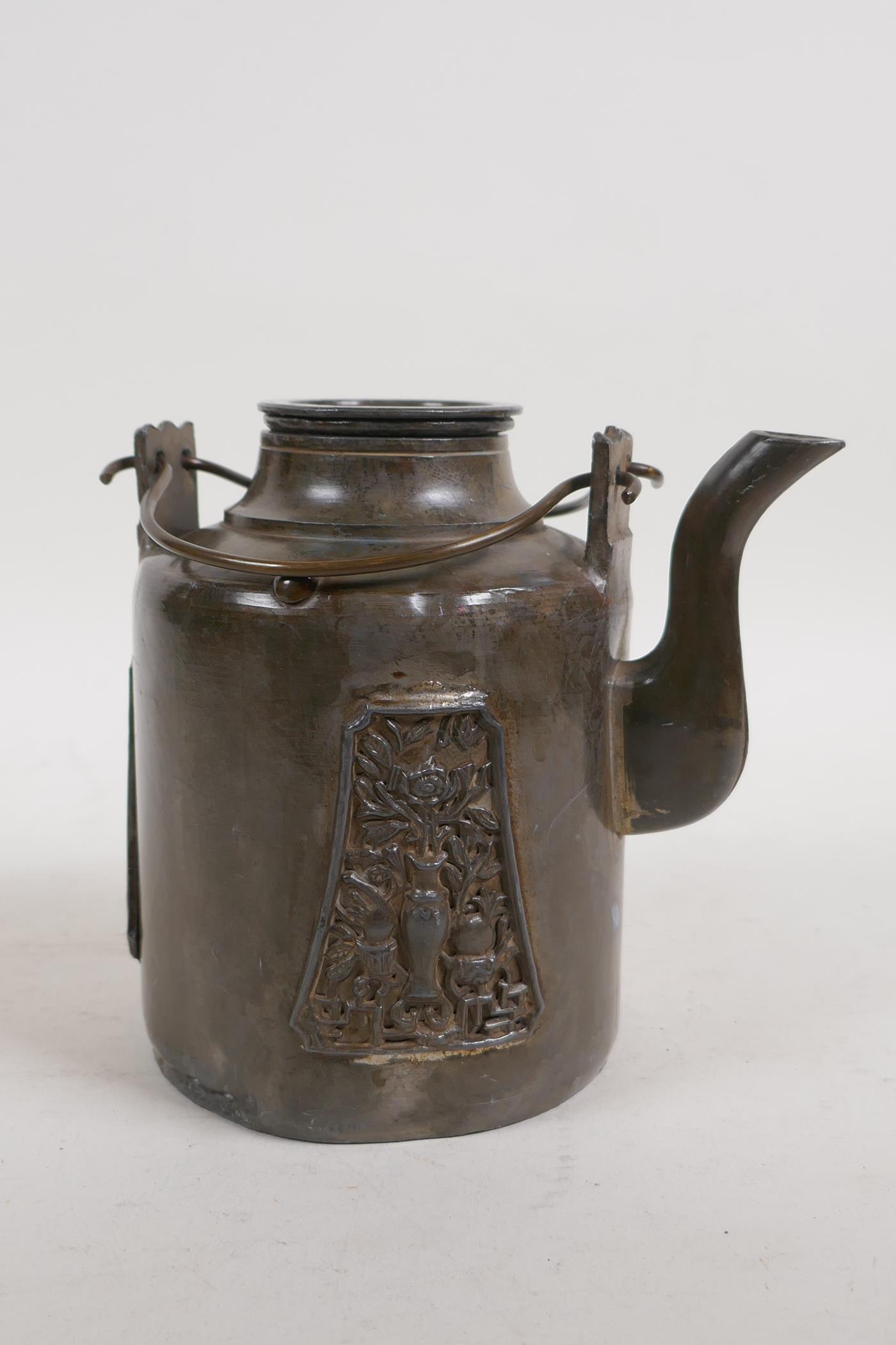 An antique Chinese pewter tea pot with applied decorative panels in relief and removable infuser/