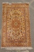 A Persian fine woven cream ground rug with a Shabaz medallion design and purple borders, faded, 41½"