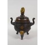 A Chinese bronze censer and cover with two elephant mask handles, tripod supports and dragon knop,