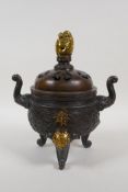 A Chinese bronze censer and cover with two elephant mask handles, tripod supports and dragon knop,