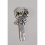 A sterling silver and mother of pearl baby's rattle in the form of an owl head, 3" long