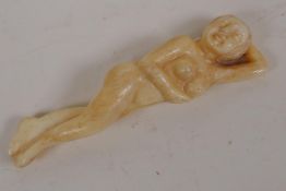 A Japanese bone okimono carved as a female nude, 3½" long