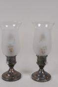 A pair of sterling silver and glass table lamps in the form of hurricane lamps, 10" high