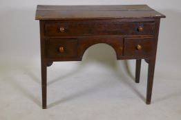 An C18th oak lowboy with one long drawer over two and central kneehole, raised on square tapering