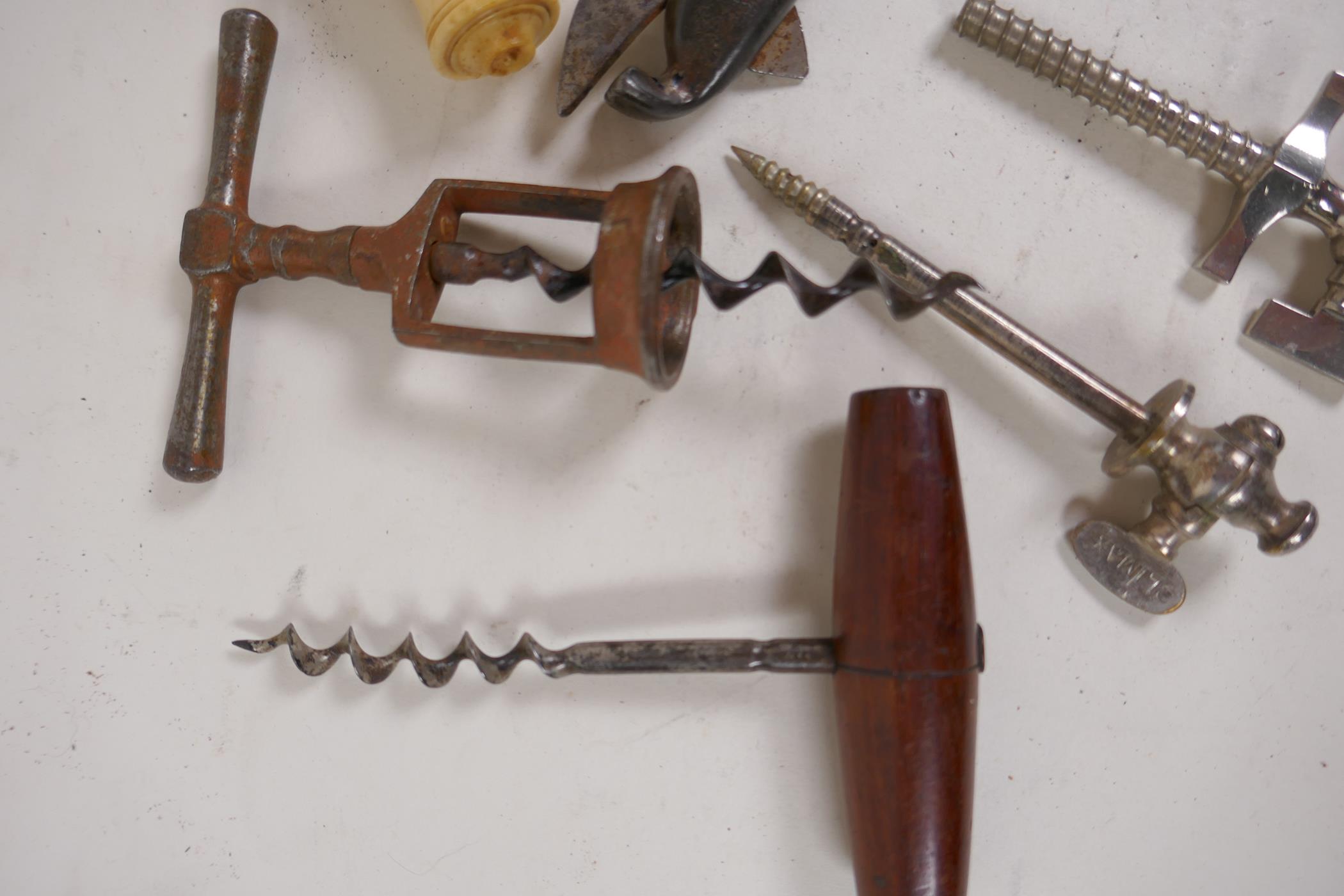 A collection of five antique corkscrews, two champagne taps and a can opener - Image 4 of 4