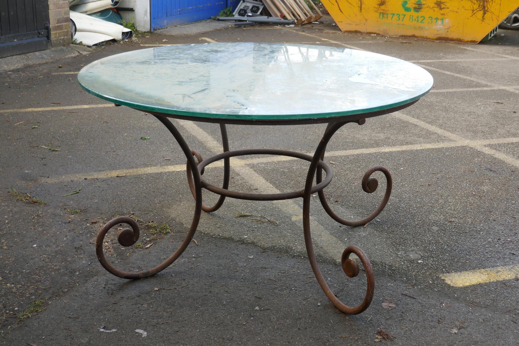 A wrought iron garden / conservatory table with plate glass top, 53" diameter, 30" high