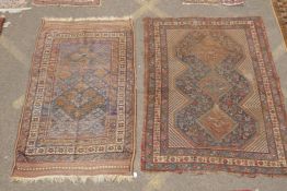 An antique Persian handwoven wool carpet with central medallions and stylised bird designs, and a