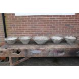 Five mid century conical concrete garden planters of varying sizes, all with bark effect