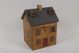 A naive wooden tea caddy in the form of a house, 8½" high