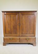 A Georgian oak press cupboard of small proportions, the upper section with fielded panel doors,