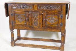 A Jacobean style oak side board with two drawers over cupboards raised on turned supports with