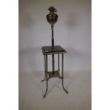 A Victorian gilt steel piano lamp, with oil lamp in basket and two tiers, the upper with painted