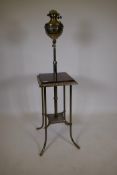 A Victorian gilt steel piano lamp, with oil lamp in basket and two tiers, the upper with painted