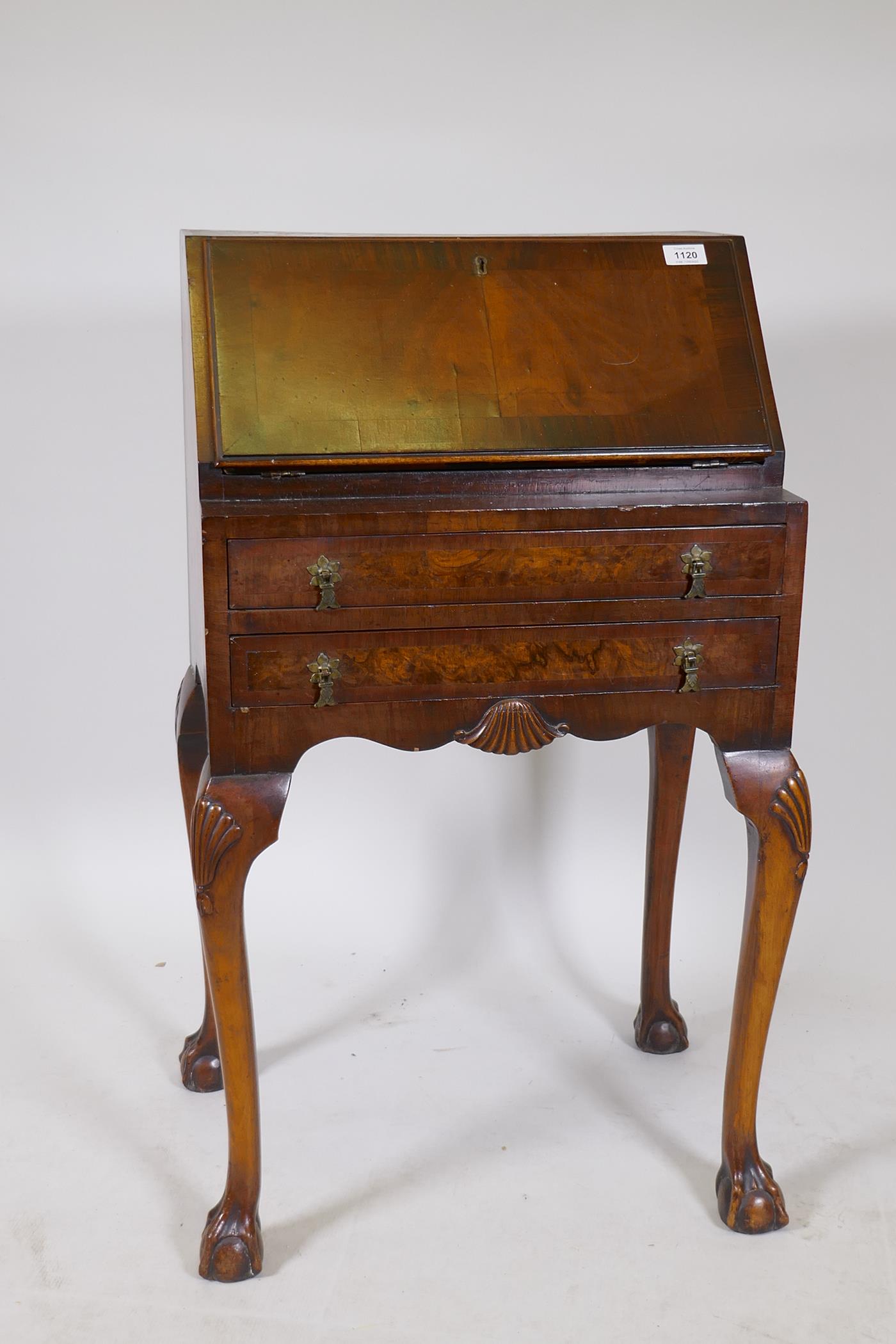 A 1920s Georgian style walnut fall front bureau with a fitted interior, two long drawers, cabriole
