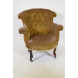 A C19th armchair with scroll back, raised on shaped supports with brass castors