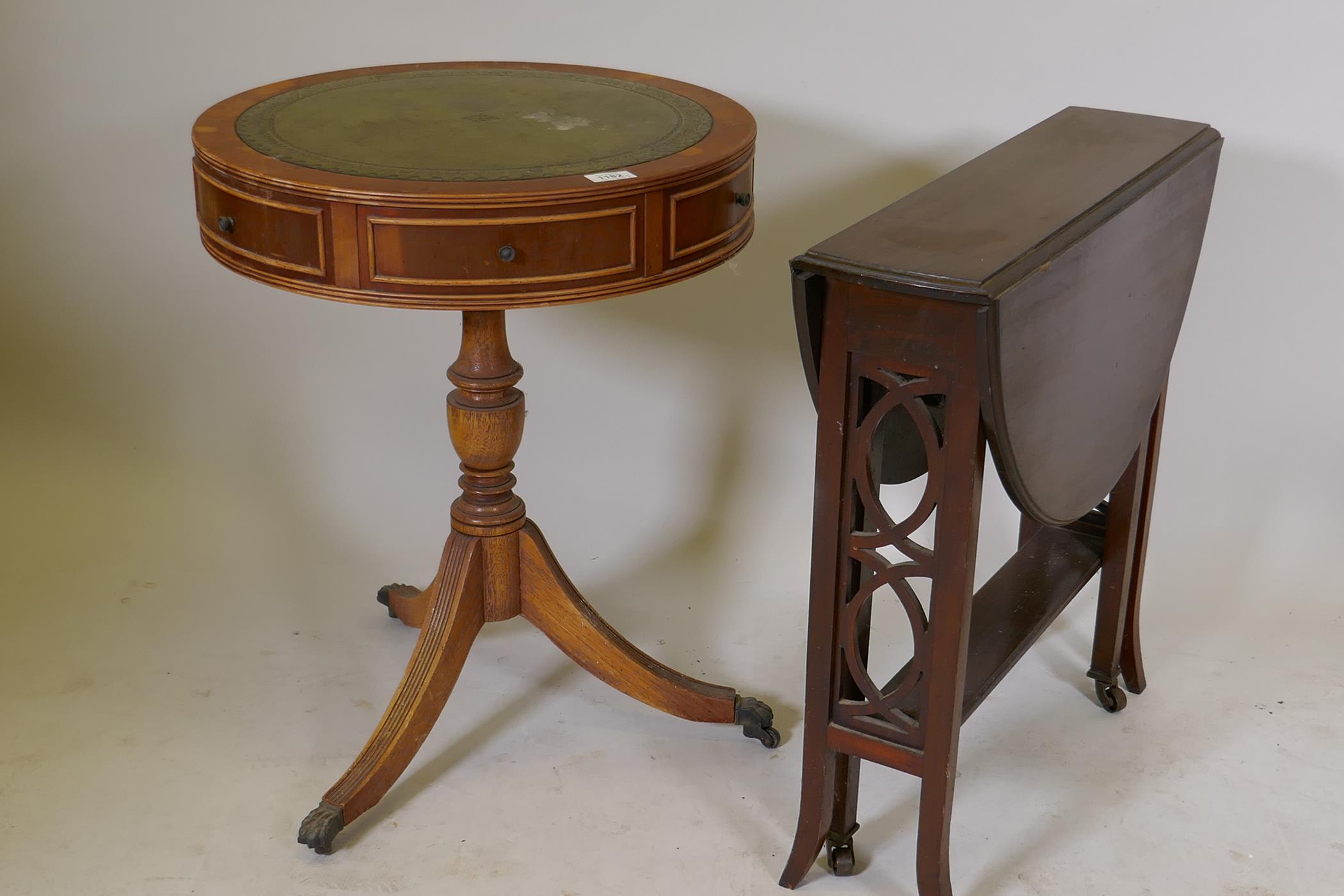 A small yew wood drum table with inset leather top, two true and four false drawers, raised on