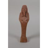 An Egyptian terracotta shabti with impressed hieroglyphs, 4½" high