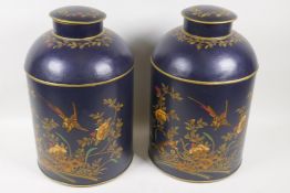 A pair of toleware covered containers decorated with exotic birds and flowers, 14" high