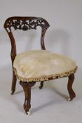 A Victorian walnut parlour chair with carved and pierced back, raised on cabriole supports