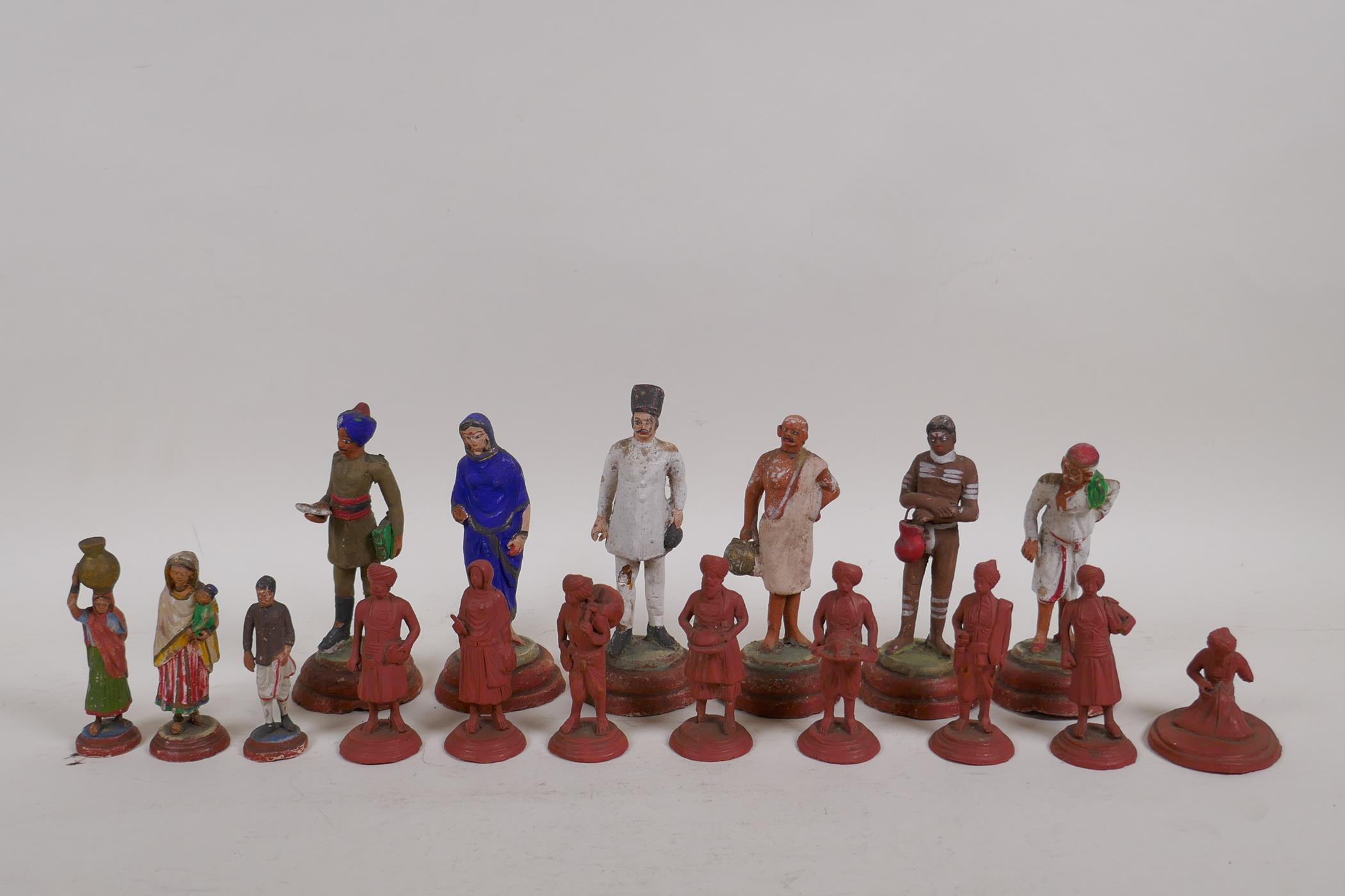 A collection of Indian terracotta figures depicting different trades people, some painted, largest
